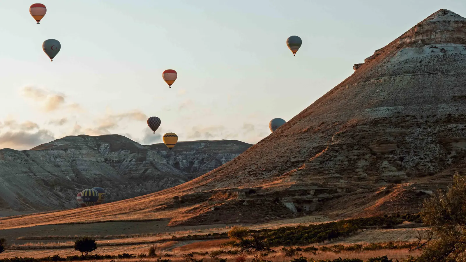 Hot air balloons over the Cappadocian valleys at sunrise