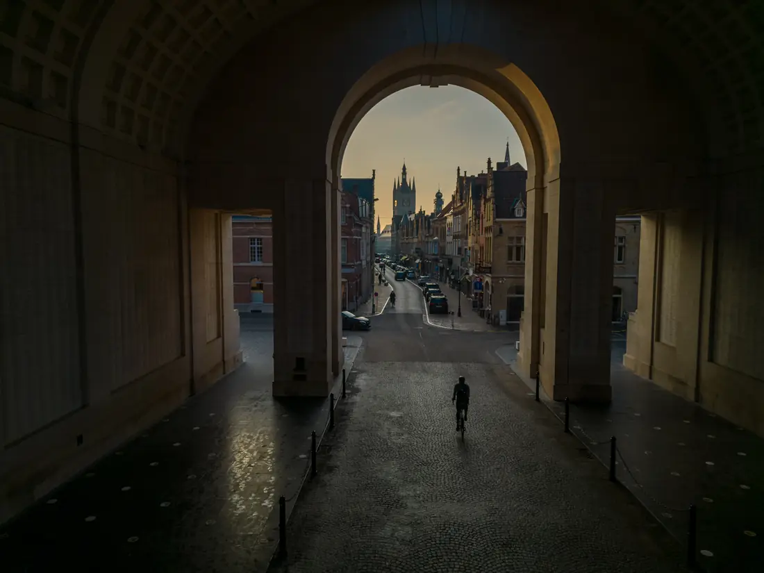 A cyclist riding out through the Menin Gate in Ypres at first light