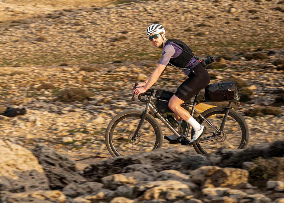Loek Luijbregts riding a loaded gravel bike through rocky terrain in Morocco